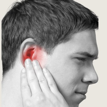 how-to-track-symptoms-sq Man touching his ear while noticing a symptom